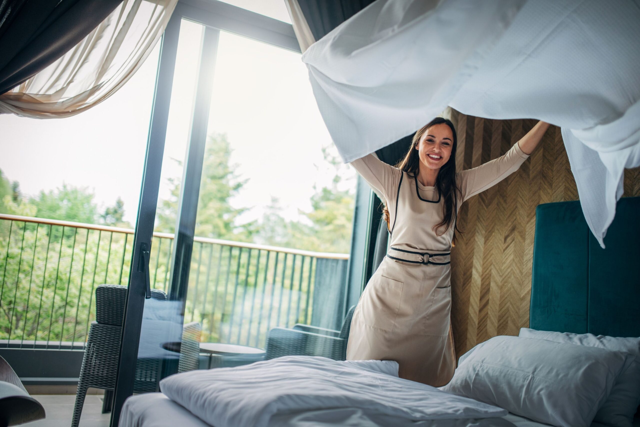 mujer haciendo la cama en una habitación